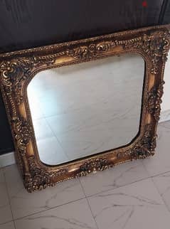 Decoratively framed wall mirror (80cm X 80cm).
