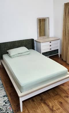 single bed with mattress and side table