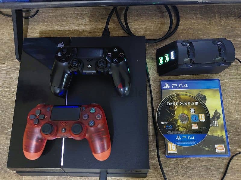 PS4 1TB with 2 controllers, charging stations, and 1 CD 0