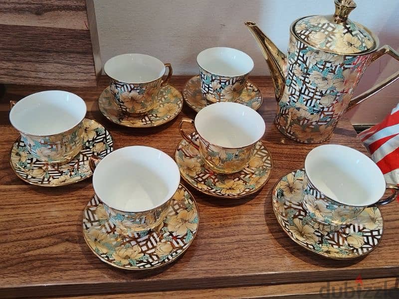 a beautiful golden tea set just like new only 1 cup slightly chipped . 2