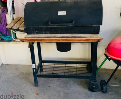 outdoor charcoal grill with a wooden stand and a trolley in excellent