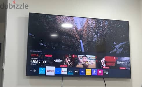 55 “Samsung 4K UHD Smart TV, complete with remote control and stand.