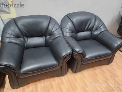 Two comfy leather single-seater sofas