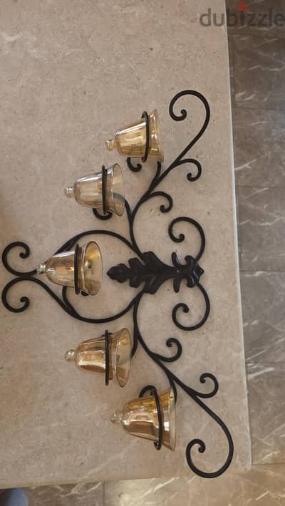 black iron wall mounted candle holder with six amber tinted glass